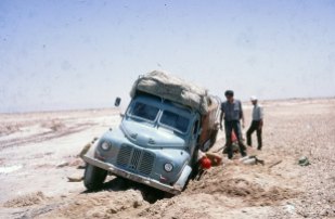 YNK229F sank through the crust in the salt desert in Iran - the Dasht-e Lut . After 24 hours digging the truck still could not be extracted. Eventually, a tractor was found to pull it out. Larry Weiss is standing next to the truck; Martin Hayes is on the right.
